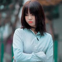 얼굴을 찡그리며 옆을 보고 있는 여자