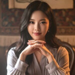 테이블에 앉아 미소짓고 있는 여성