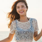 바닷가에서 모자를 잡으며 달리는 모습